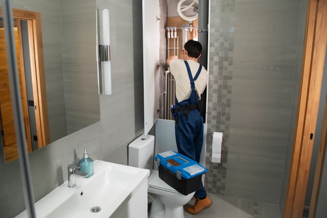 Plumber inspecting water heater and pipes